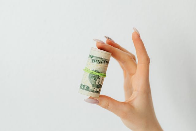 person holding a roll of money